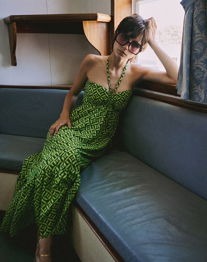 Regalinas Editorial: A model wearing Regalinas clothing sits elegantly by the window on a ferry boat